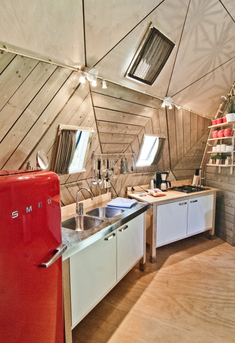 Cocina moderna en la tiny house Wooden Igloo en Holiday Park Delftse Hout, Países Bajos, con nevera SMEG roja.