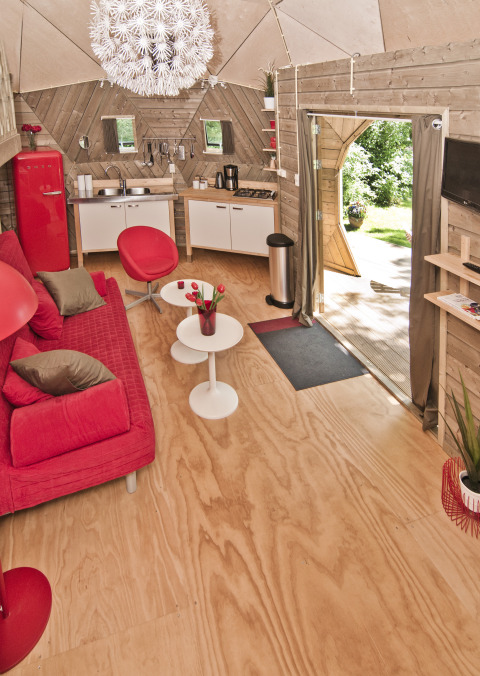 Indretning af det lille hus Wooden Igloo i Holiday Park Delftse Hout, Holland, med røde møbler.