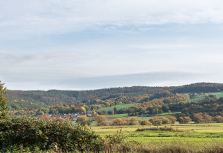 Landskab omkring Niederaula, Tyskland, set fra en hytte med grønne marker og skovklædte bakker.