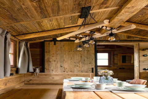 Intérieur en bois d'une tiny house avec table dressée et éclairage rustique en Allemagne.