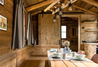 Intérieur d'une tiny house en bois en Allemagne, table à manger, murs en bois et ambiance chaleureuse.