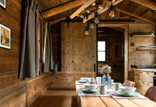 Interior de una tiny house de madera en Alemania, mesa de comedor y ambiente acogedor y rústico.