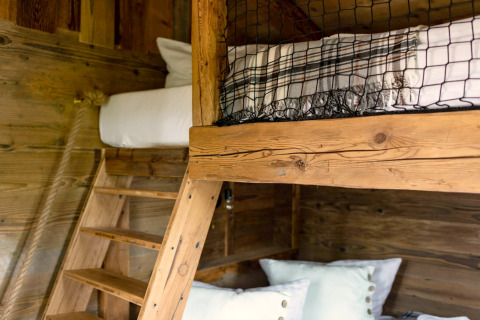 Lit superposé en bois avec échelle et coussins dans une tiny house en Allemagne, décor rustique.