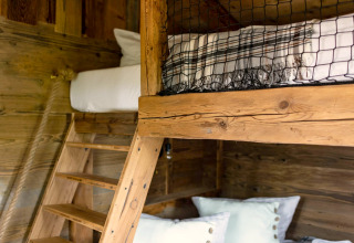 Lit superposé en bois avec échelle et coussins dans une tiny house en Allemagne, décor rustique.
