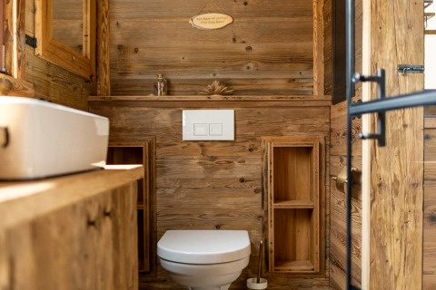 Salle de bain moderne en bois dans une tiny house en Allemagne, avec WC, lavabo et lumière naturelle.