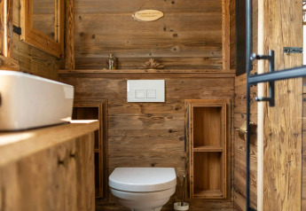 Salle de bain moderne en bois dans une tiny house en Allemagne, avec WC, lavabo et lumière naturelle.