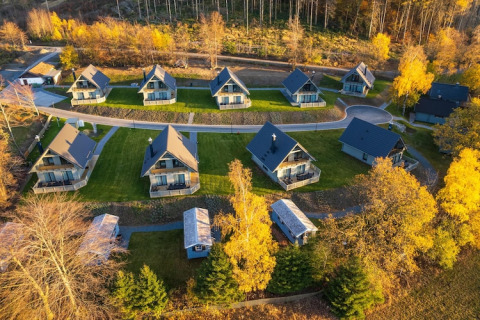 Vista aérea de casas pequeñas y modernas rodeadas de árboles otoñales en una zona pintoresca de Alemania.