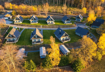 Vue aérienne de petites maisons modernes entourées d’arbres d’automne dans une région pittoresque d’Allemagne.