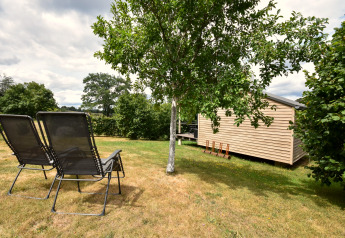Vakantiehuis «Terra 2 Persons» in Duitsland met twee ligstoelen en houten chalet in de tuin.