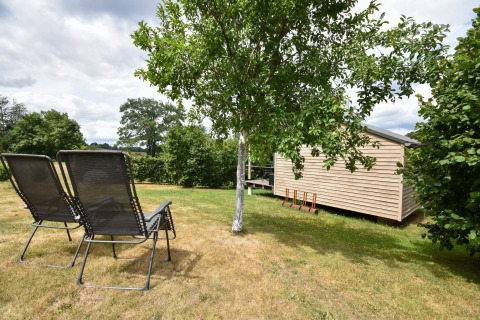 Casa mobile Holiday home «Terra 2 Persons» in Germania con due sdraio e casetta in legno in giardino.
