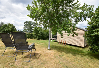 Mobil home Holiday home «Terra 2 Persons» en Allemagne, avec deux chaises longues et un jardin arboré.