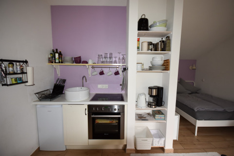 Compact kitchenette and sleeping area in mobile home Holiday home «Terra 2 Persons» in Germany with modern decor.