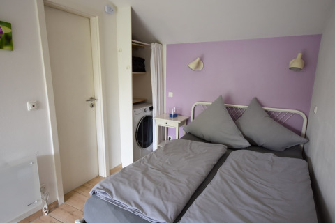 Bedroom in mobile home Holiday home Terra 2 Persons in Germany with double bed and purple wall.