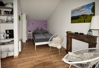 Moderne mobilhome Holiday Home Terra 2 Persons i Tyskland med dobbeltseng, stole og tekøkken.