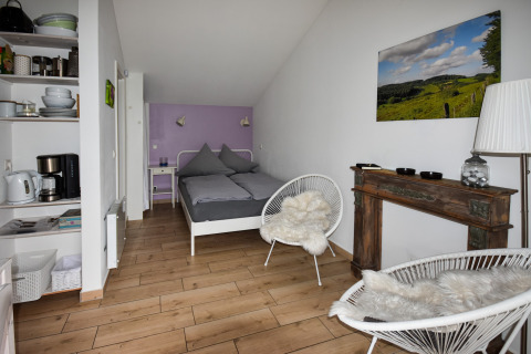Casa móvil moderna Holiday Home Terra 2 Persons en Alemania con cama, estantería y zona de cocina.
