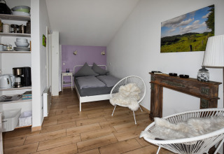 Moderne mobilhome Holiday Home Terra 2 Persons i Tyskland med dobbeltseng, stole og tekøkken.