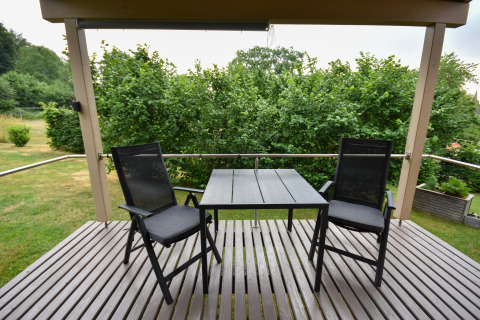 Udendørs terrasse med to sorte stole og bord på Holiday home «Terra 2 Persons» i Tyskland.