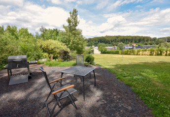 Tuin bij Holiday Home Terra 2 Persons in Duitsland met barbecue, tafel, stoelen en uitzicht op het landschap.