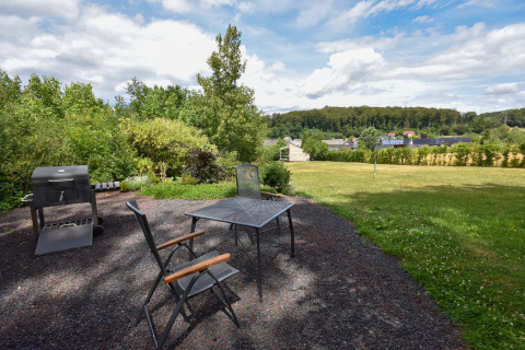Area giardino alla Holiday Home Terra 2 Persons in Germania con barbecue, tavolo, sedie e vista paesaggistica.