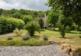 Grøn have med buske og træer foran et mobilhome, Holiday home Terra for 2 personer i Tyskland.