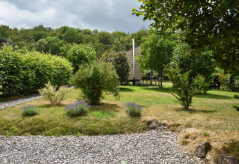 Jardin verdoyant avec buissons et arbres devant la maison mobile Holiday home Terra 2 Persons en Allemagne.