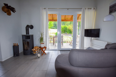 Salón moderno en Holiday home Magma 2 Persons, Alemania, con estufa y vista a la terraza exterior.