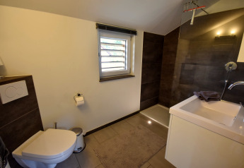 Moderne badeværelse med bruser, toilet og håndvask i ferieboligen Magma 2 Persons, Tyskland.