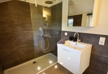 Salle de bain moderne du Holiday home Magma 2 Persons en Allemagne avec douche et meuble vasque blanc.
