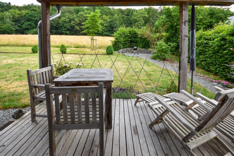 Houten terras met tuinmeubilair en uitzicht op de tuin bij vakantiewoning Magma 2 Persons in Duitsland.