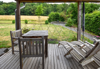 Houten terras met tuinmeubilair en uitzicht op de tuin bij vakantiewoning Magma 2 Persons in Duitsland.