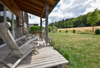Houten terras met stoelen bij Holiday home ‘Magma 2 Persons’, zicht op een veld in Duitsland.
