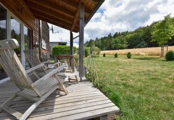 Wooden deck with lounge chairs at Holiday home ‘Magma 2 Persons’, overlooking a scenic field in Germany.