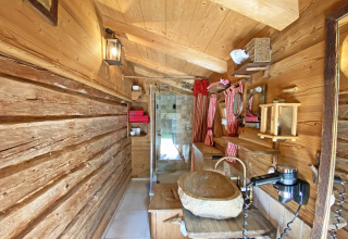 Rustieke houten badkamer in chalet Almhütte in Duitsland met stenen wasbak en roodgeruite gordijnen.