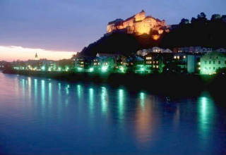 Abendaufnahme von beleuchtetem Schloss auf Hügel bei Fluss, fotografiert von Almhütte, Deutschland.