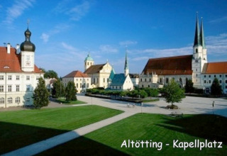 Kapellplatz in Altötting, Deutschland, mit Kirchen, historischen Gebäuden und gepflegtem Grün bei Sonnenschein.