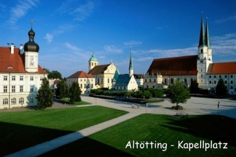 Gezicht op Kapellplatz in Altötting, Duitsland, met kerken en historische gebouwen bij zonnig weer.