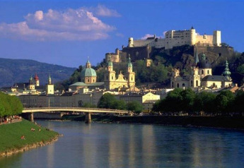 View of Salzburg’s Old Town and Hohensalzburg Fortress perched on a hill above the river, Austria.