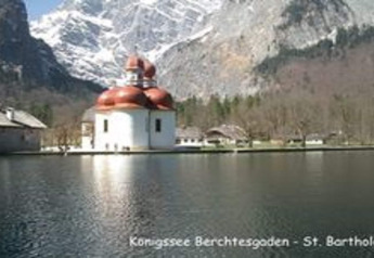 View of St. Bartholomä on Lake Königssee near the Almhütte chalet in Berchtesgaden, Germany, with mountains.