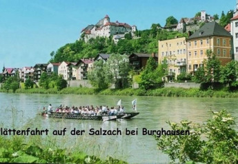 Boat ride on the Salzach River near Burghausen with colorful houses and the castle in the background.