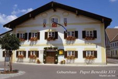 Afbeelding van een traditioneel chalet in Duitsland, geboortewoning van paus Benedictus XVI, met tekst.
