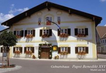 Photo of a traditional chalet in Germany, marked as the birthplace of Pope Benedict XVI on the building.