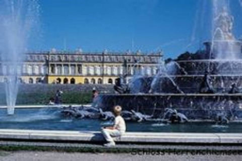 Grote fontein en paleis op de achtergrond bij Schloss Herrenchiemsee, Duitsland, mensen genieten van de zon.