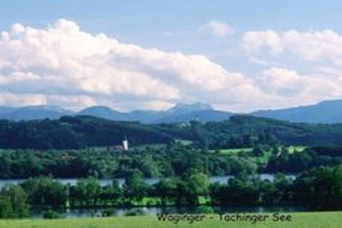 Uitzicht vanaf chalet Almhütte in Duitsland op de Waginger-Tachinger See, met bossen en heuvels op de achtergrond.