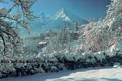 Winterblick von der Almhütte in Berchtesgaden, Deutschland, mit verschneiten Bergen und Dorf.
