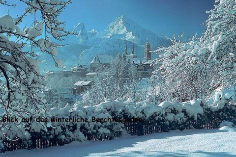 Winterzicht vanuit chalet Almhütte in Berchtesgaden, Duitsland, met besneeuwde bergen en dorp.