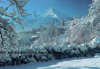 Winter view from the Almhütte chalet in Berchtesgaden, Germany, showing snowy mountains and village.