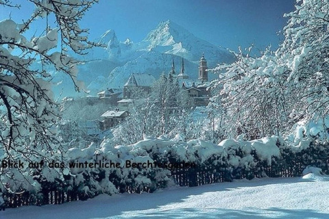 Winterse aanblik vanaf chalet Almhütte in Berchtesgaden, Duitsland, met besneeuwde bomen en bergen.