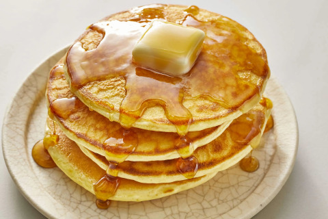 Een stapel pannenkoeken met boter en stroop op een bord in chalet Almhütte in Duitsland.