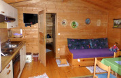 Interno dello chalet Steingaden in Germania con pareti in legno, angolo cucina e divano.