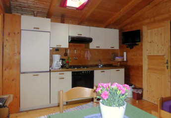 Accogliente cucina in uno chalet a Steingaden, Germania, con pareti in legno e tavolo da pranzo.